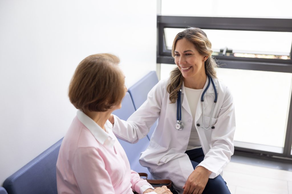 Physician speaking with an older patient during a supportive consultation.
