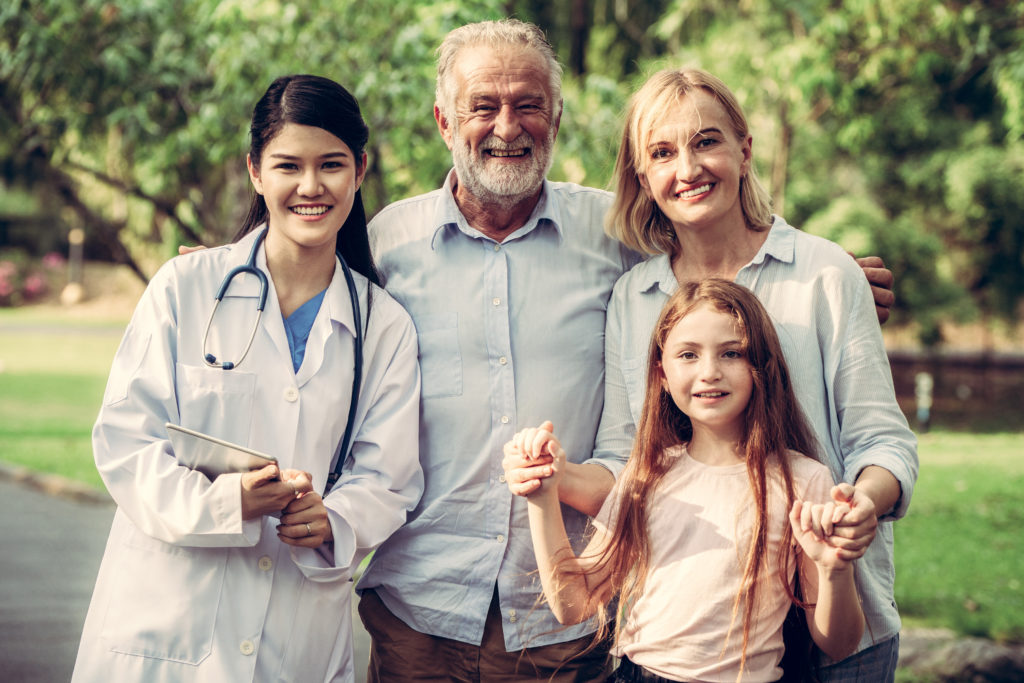 Happy healthy family and doctor talking in the park. People healthcare and medical staff service concept.
