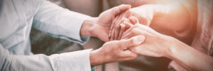 Midsection of therapist holding patient hands