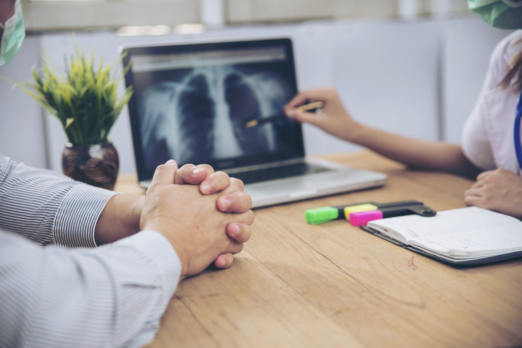 Bad news for medical diagnosis,Serious patients are listening x ray scan results from professional doctor.Patient and doctor concept