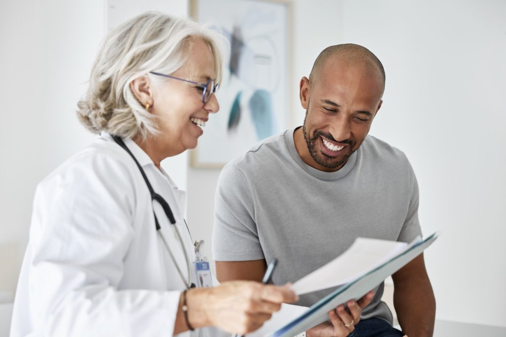 Physician reviewing paperwork with a patient during an oncology visit.